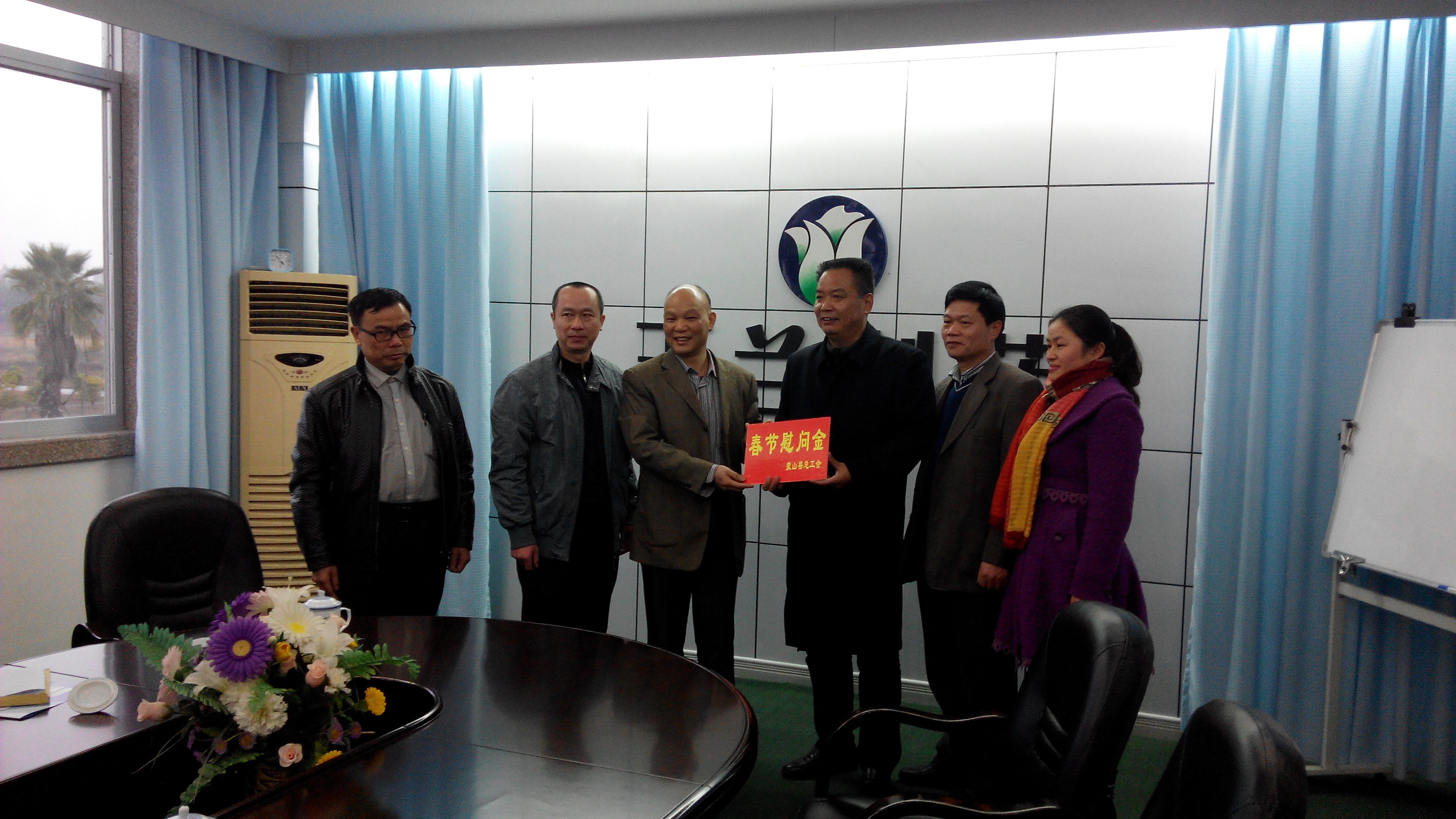 1月28日，梧州市總工會副主席謝海益帶隊到蒙山開展春節(jié)前慰問活動。圖為市總工會謝副主席給玉蘭制藥公司送上春節(jié)慰問金。--